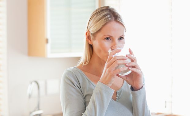 Frau trinkt Wasser für eine gesunde Blase Frau trinkt Wasser für eine gesunde Blase
