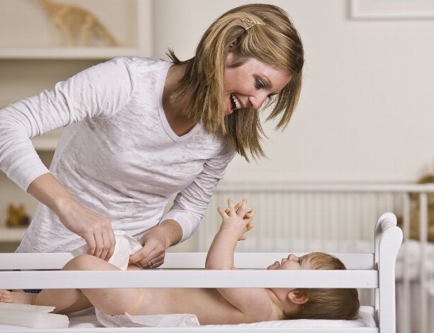 Mama und Baby haben Spaß beim Wickeln