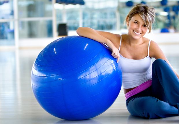 Glückliche Frau mit Pilates Ball