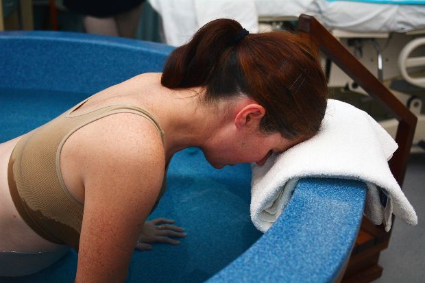Frau gebärt ihr Kind im Wasser